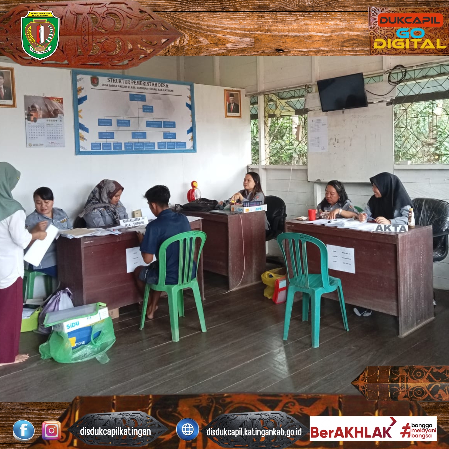 .  Seorang petugas Dukcapil menyerahkan dokumen kependudukan yang sudah selesai kepada warga