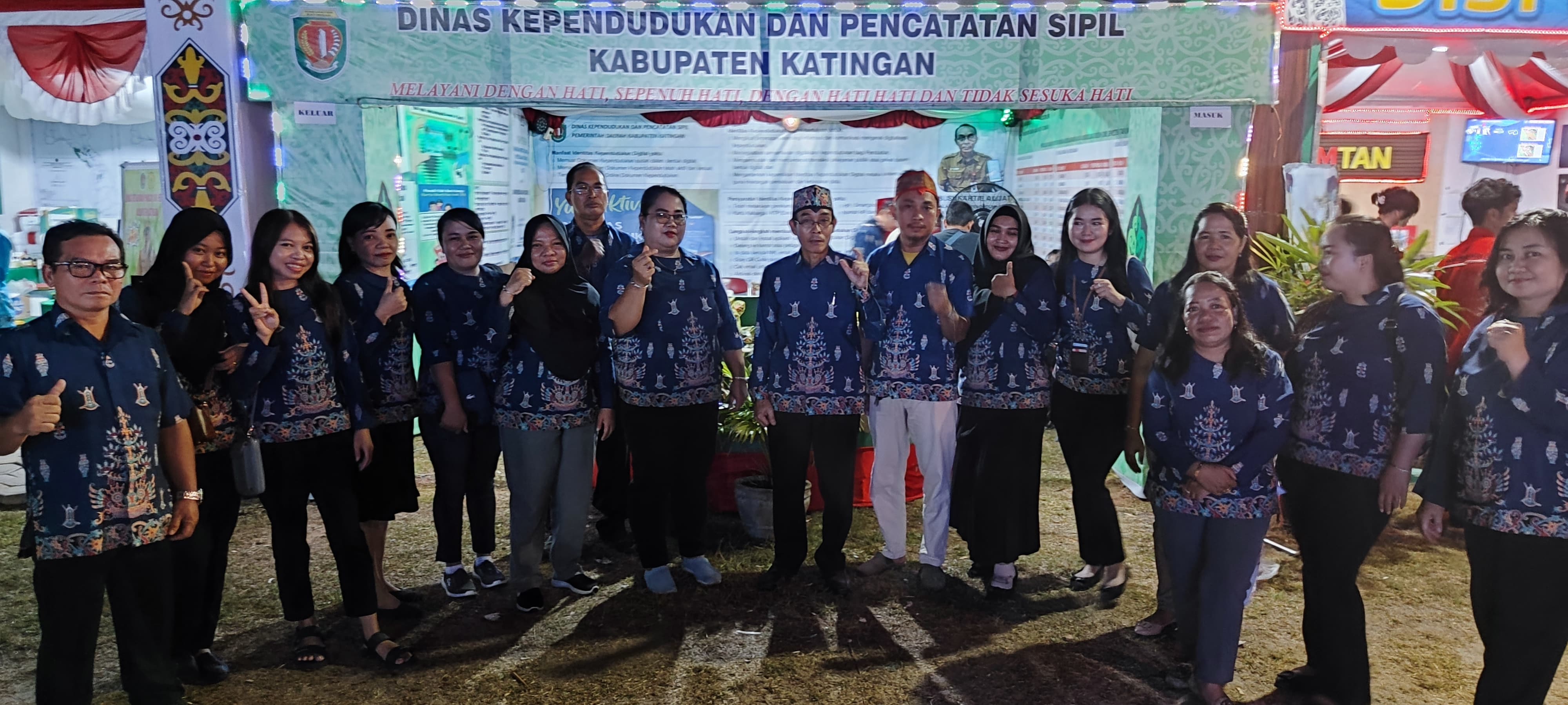 Pegawai berfoto bersama di depan Stand Pameran Disdukcapil