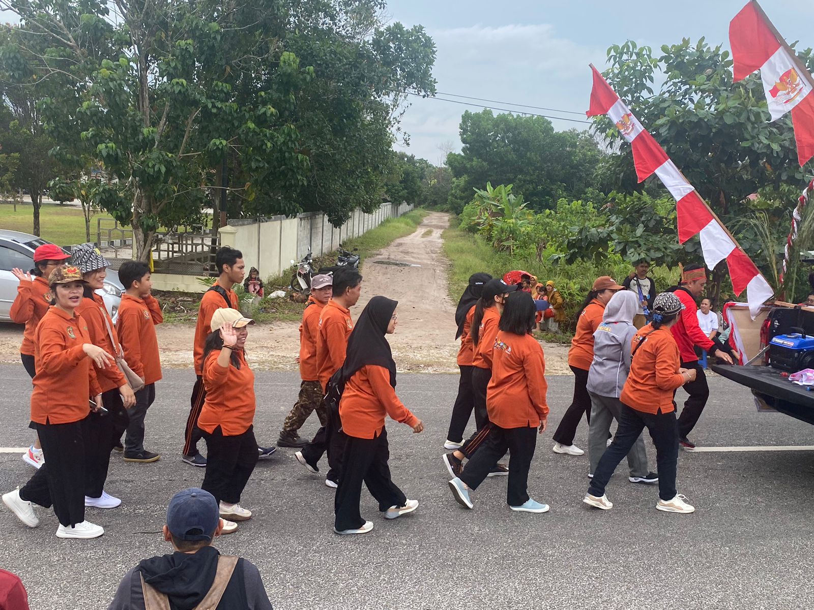 Barisan pegawai dukcapil berjalan rapi di belakang mobil hias